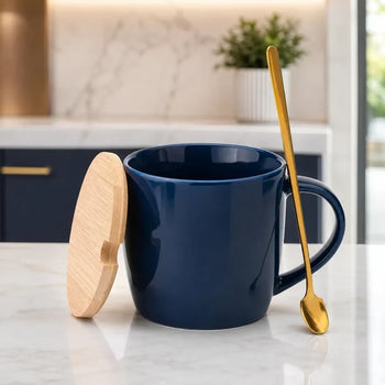 A navy blue ceramic mug with a matching wooden lid leaning against it, set on a white marble countertop in a kitchen. A go...